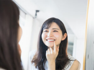 鏡で歯を見る女性